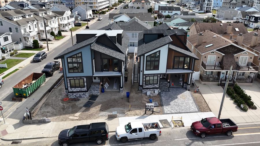 Two modern homes under construction in Wildwood Crest, with dark trim and large windows