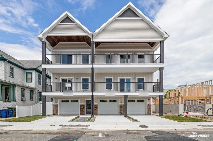 Three-unit townhome with covered balconies and three garages